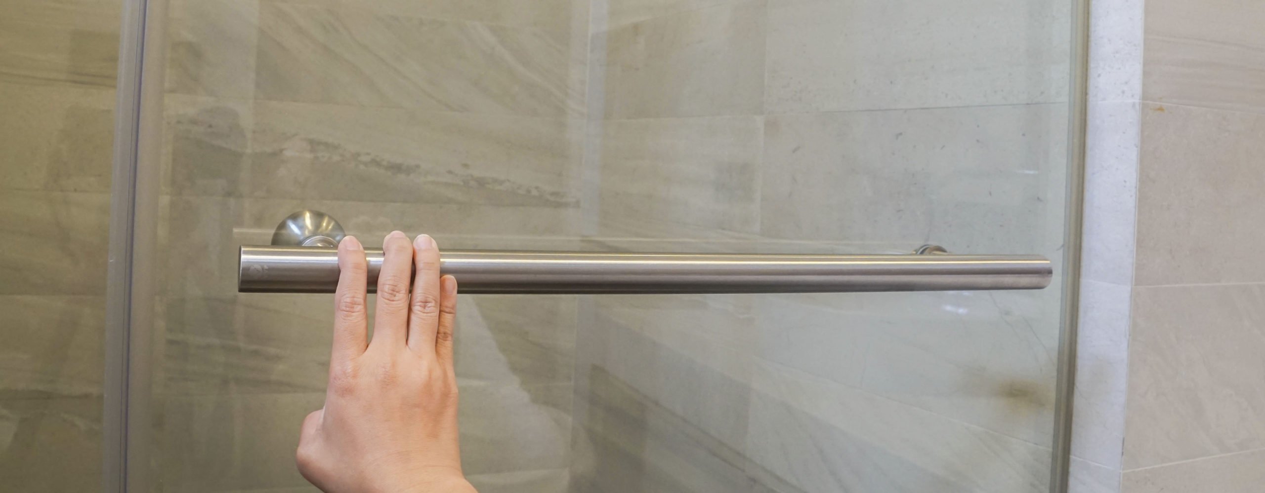 hand on shower door bar